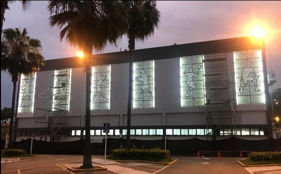 Fachada de edificio en remodelación con andamios e iluminación